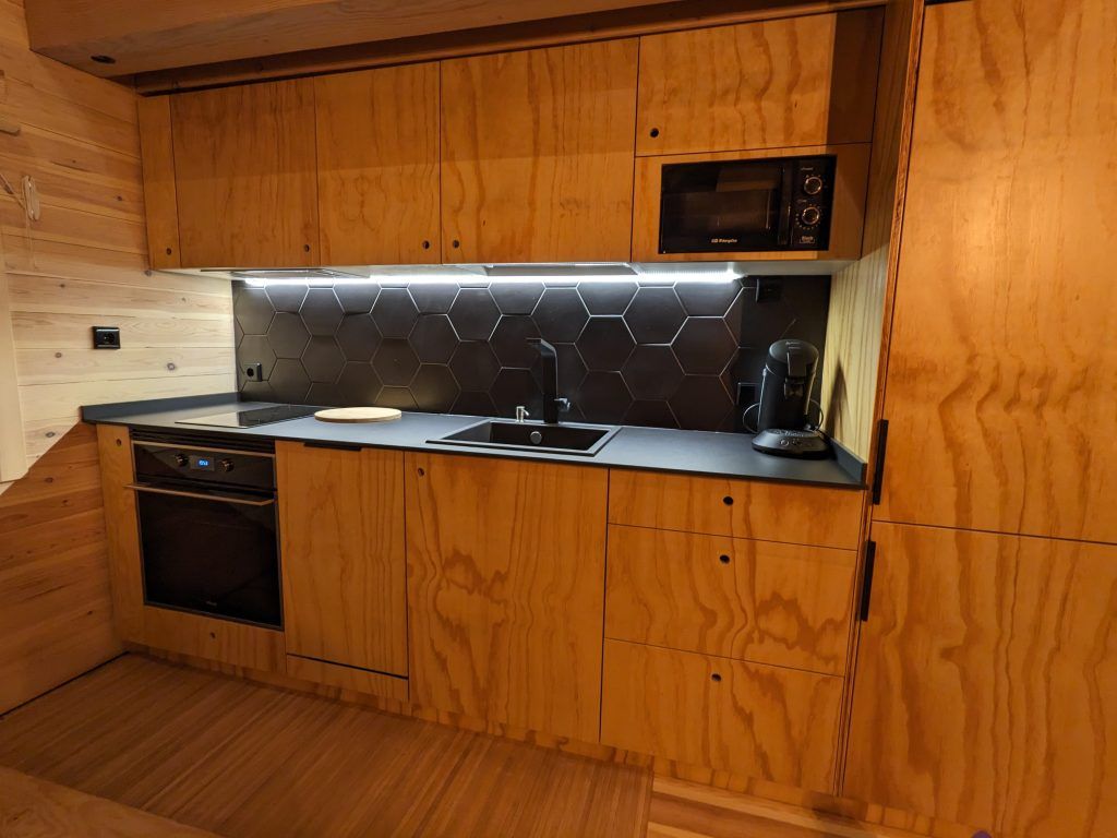 Cocina abierta al salon de madera y negro