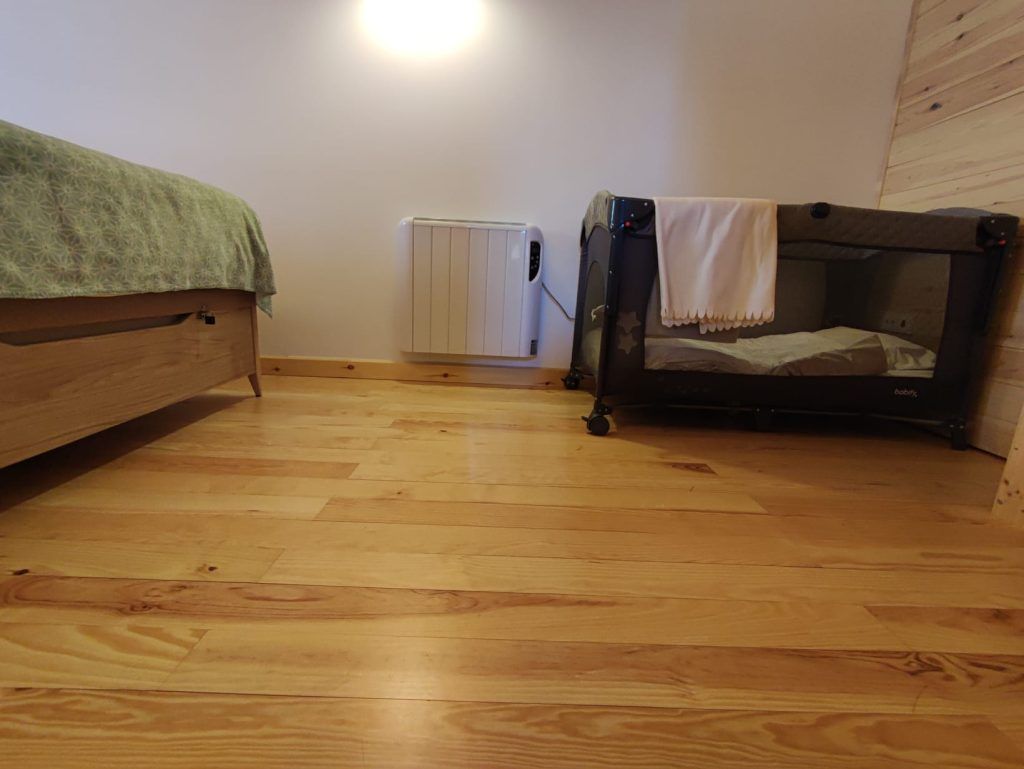Habitación inferior con cama de matrimonio en Casa Nornore donde se puede añadir cuna